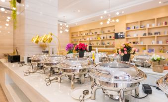 There is a large white table in the center with various items on it, along with additional tables behind it at Kaili Yade Hotel(Dongguan Huangjiang Jinyi Branch)