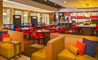 a dining area with several red chairs and couches , creating a warm and inviting atmosphere at Courtyard Manassas Battlefield Park