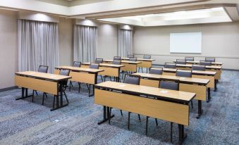 a large conference room with multiple rows of chairs arranged in a semicircle , and a whiteboard on the wall at Courtyard Harlingen