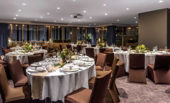 a well - decorated dining room with multiple tables and chairs arranged for a formal event , possibly a wedding reception at Novotel Sydney Darling Harbour