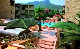 a large resort with a pool and multiple buildings is surrounded by trees and mountains at Havana Hotel