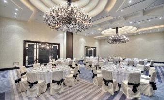 a large dining room with white tablecloths , chairs , and chandeliers hanging from the ceiling at AX The Palace