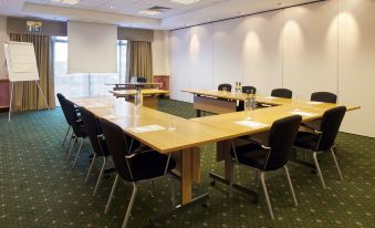 a conference room with a long table , chairs , and papers on it , set up for a meeting at Holiday Inn Glasgow - East Kilbride