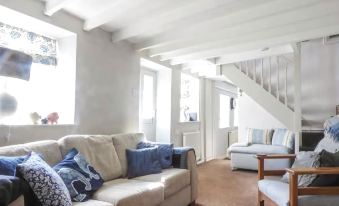 a cozy living room with a couch , two chairs , and a staircase leading to the second floor at Garden View