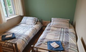 two beds with striped bedding and blue blankets are placed next to each other in a room at The Loft