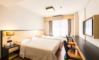 A bedroom with double beds, a desk, and a chair is located in front of a large window at Rayfont Hotel & Apartment Chengdu
