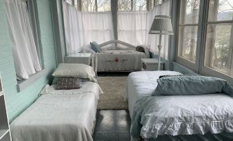 a cozy bedroom with three beds , one on the left , one in the middle , and one on the right at Susquehanna Manor Inn