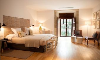 a large bedroom with two beds , one on the left side of the room and the other on the right side at Parador Monasterio de Corias