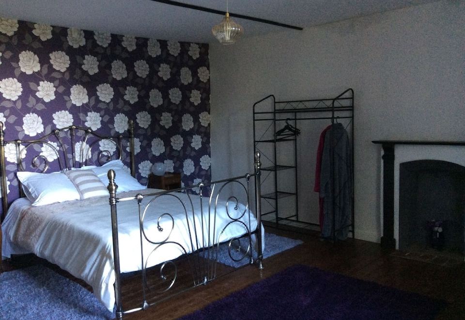 a bedroom with a white bed , a black bed frame , and a purple rug on the floor at Serendipite