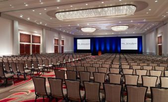 a large conference room with rows of chairs arranged in front of a stage , ready for an event at Omni Providence Hotel