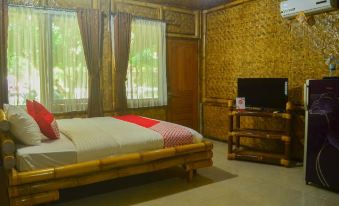 a bedroom with a wooden bed , television , and window , featuring bamboo walls and bamboo blinds at Shane Josa Resort
