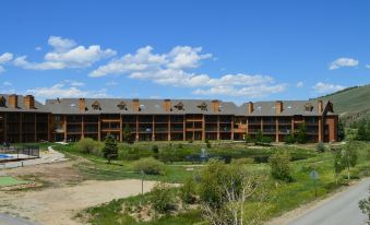 a large , multi - story building with a parking lot in front of it and trees surrounding the area at The Inn at Silvercreek