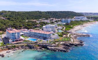 an aerial view of a beach resort with multiple buildings and a swimming pool , situated near the ocean at Villa Le Blanc Gran Melia