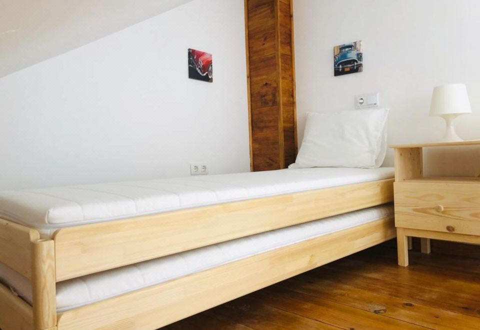 a wooden bunk bed in a small room , with two mattresses on the bottom bunk at Bellevue