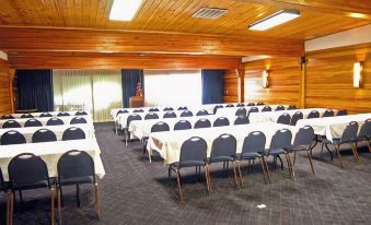 a large conference room with rows of chairs arranged in a semicircle , and a podium at the front of the room at Best Western Edgewater Resort