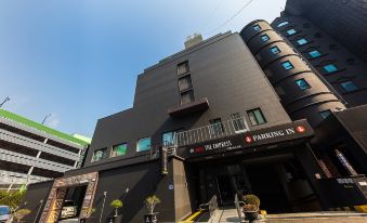 "a modern building with a black facade and large windows , featuring the words "" the empire "" on the sign" at The Empress Hotel