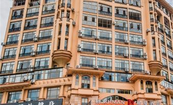 The front and side views of a tall building in an urban area at Kela Hotel