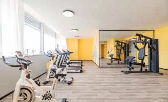 a well - equipped gym with various exercise equipment , including treadmills , stationary bikes , and weight machines at Atour Hotel