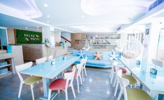 a modern restaurant with blue and white furniture , a bar , and a dining area decorated with starfish at Palau Hotel