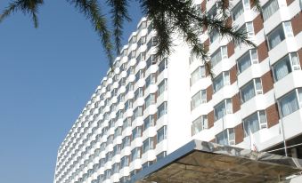"There is a large building in front with an exterior view and the word ""hotel"" displayed on top" at Jinglun Hotel