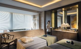 revised to create a spacious and well-lit middle room with a large bed, table, and windows that provide a view of another bedroom at Four Seasons Hotel Shenzhen
