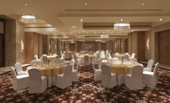 a large banquet hall with multiple tables and chairs set up for a formal event , possibly a wedding reception at DoubleTree by Hilton Agra