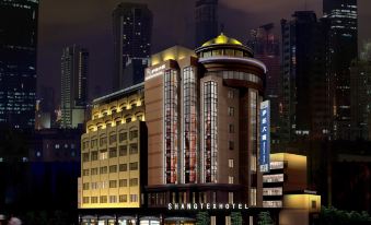 "At night, a large illuminated building with the word ""hotel"" on its façade stands in front" at Shangtex Hotel