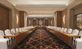 a large conference room with long tables and chairs arranged in rows , ready for a meeting or event at DoubleTree by Hilton Agra