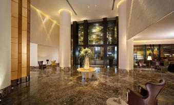 a spacious room with marble floors and tables in the center, adjacent to an entrance at Empire Hotel Hong Kong－Wan Chai