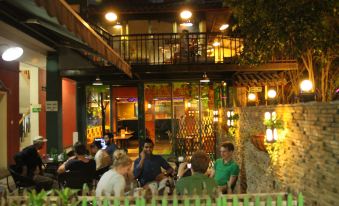 A group sits outside in the city center at night, surrounded by standing people at Beehome  Hostel