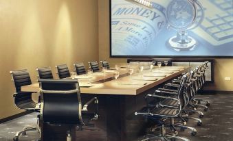 a large conference room with a long wooden table and several chairs arranged around it at Sol Hotel