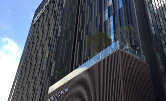 The urban setting showcases tall buildings and a clear blue sky as seen from outside a hotel at Hotel Midtown Richardson