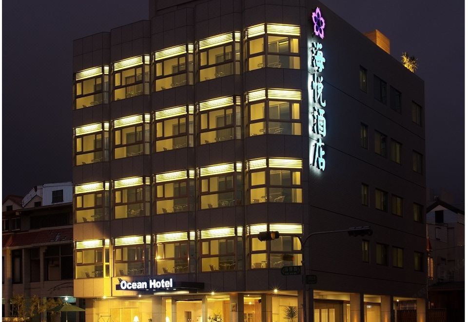 a large hotel building with multiple floors and windows , lit up at night against the dark sky at Ocean Hotel