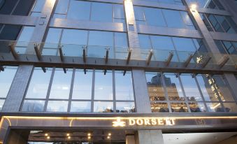 The hotel's front entrance features a glass facade and a stone-clad entryway at Dorsett Tsuen Wan