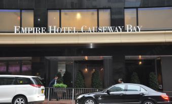 At the entrance of a hotel, cars are parked in front and an ornate sign hangs above at Empire Hotel Hong Kong - Causeway Bay