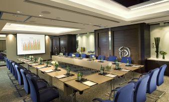 The hotel offers a spacious conference room equipped with blue chairs and long tables, suitable for meetings and other business events at Regal Hongkong Hotel