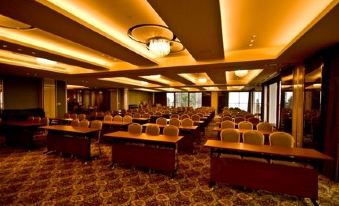 a large conference room with multiple rows of chairs arranged in a semicircle , providing seating for attendees at Alishan House