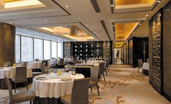 In the center of the restaurant, there are tables and chairs arranged in a way that they all face each other at Cordis, Hong Kong