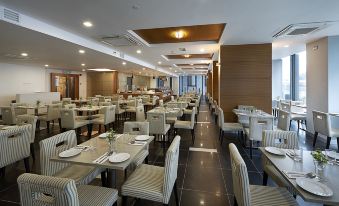 The restaurant features large marble tables and brown wood paneling on its dining room walls at Hotel Transit Kuala Lumpur