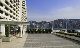 The rooftop offers a scenic view of the surrounding urban area, including water and other buildings at Marco Polo Hongkong Hotel