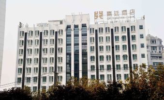 On a sunny day in an urban setting, there are clear front and side views of a large white building at Kingtown Hotel Plaza Shanghai