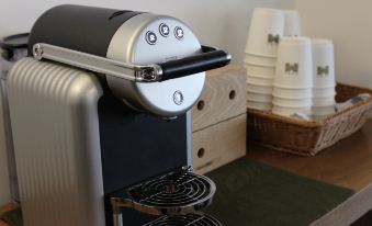 There is a close-up view of a coffee maker and espresso machines in a two-person office at Mini Central
