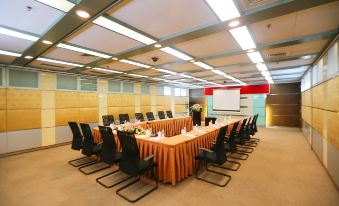 There is a spacious conference room arranged with long tables and chairs for hosting events or meetings at Shanghai Baoan Hotel