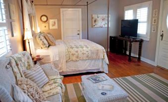 a cozy bedroom with a large bed , hardwood floors , and a tv mounted on the wall at Fiddler's Inn
