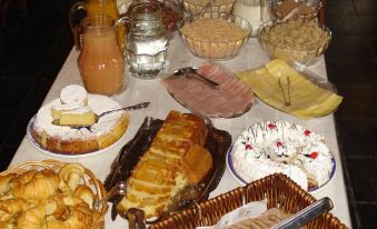 a dining table filled with a variety of food items , including sandwiches , cakes , and drinks at Village Condo