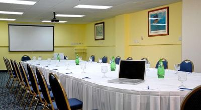 a conference room with a long table , chairs , and a laptop on the table , surrounded by chairs at Wyndham Reef Resort Grand Cayman