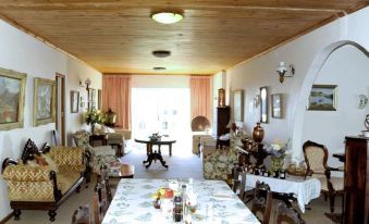 a spacious living room with wooden furniture , including a dining table and chairs , a couch , and a television at Whale Watchers Inn