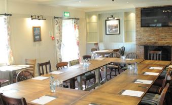 a large conference room with wooden tables , chairs , and a window , set up for a meeting or event at Sturdys Castle