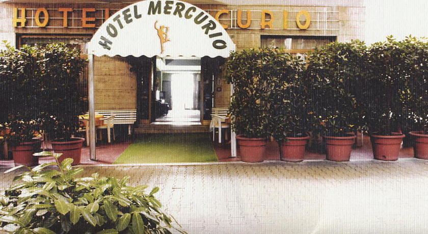 the entrance of a hotel mercurio with two plants and a sign above the door at Hotel Mercurio