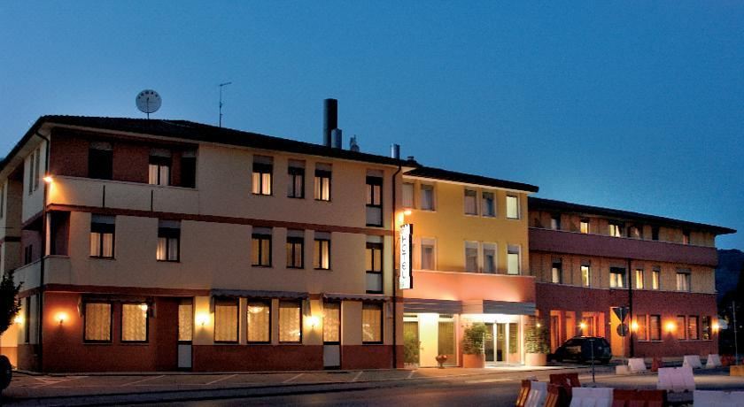 a hotel building with its entrance lit up at night , surrounded by cars on the street at Hotel Europa